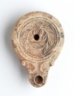Roman Oil Lamp with Wreath, 1st - 2nd century AD; height cm 2,2, length cm 9. Provenance: From the collection of a Diplomatic family since 1980s.