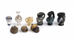 Group of Nine Greek and Roman Juglet Pendants, 2nd century BC - 2nd century AD; height max mm 24; Polychrome glass, amber and ivory. Provenance: The G...