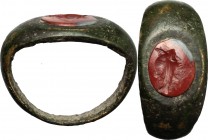 Bronze ring with carnelian intaglio engraved with "grillos" (two joined faces)." Roman period, 1st-2nd century AD." Gem 9 x 7 mm." Ring size 14,5 mm.