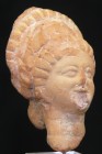Grèce - Tête en terre cuite - 200 / 100 av. J.-C.
Petite tête en terre cuite de couleur orangée représentant une femme portant une coiffe. Petit écla...