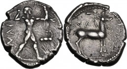 Greek Italy. Bruttium, Kaulonia. AR Stater, c. 475-425 BC. Apollo, nude, advancing right with a laurel branch in his upraised right hand and a daimon....