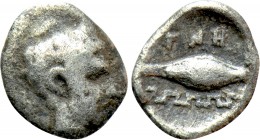 IONIA. Magnesia ad Maeandrum. Tetartemorion (Circa 400-350 BC). 

Obv: Head of Apollo right.
Rev: MAΓNH. 
Barley grain; maeander pattern to left....