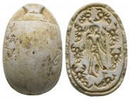 Second Intermediate Period, c. 1650-1550 B.C. Steatite scarab (23x16mm). Base engraved with a human figure standing right, holding a sceptre, surround...