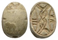 Second Intermediate Period, c. 1650-1550 B.C. Steatite scarab (15x11mm). Base engraved with a coiled cord pattern. Intact, once glazed, pierced for mo...