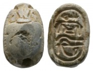 Second Intermediate Period, c. 1650-1550 B.C. Steatite scarab (14x9mm). Base engraved with protective signs. Intact with some wear on top, once glazed...