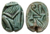 New Kingdom, c. 1550-1075 B.C. Green glazed steatite scaraboid (14x11mm). Base engraved with two opposing crowns. Back is raised and rounded and finel...
