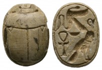New Kingdom, c. 1550-1075 B.C. Steatite scarab (17x12mm). Base finely engraved with a falcon an ankh ad a sa. Intact, once glazed, pierced for mountin...