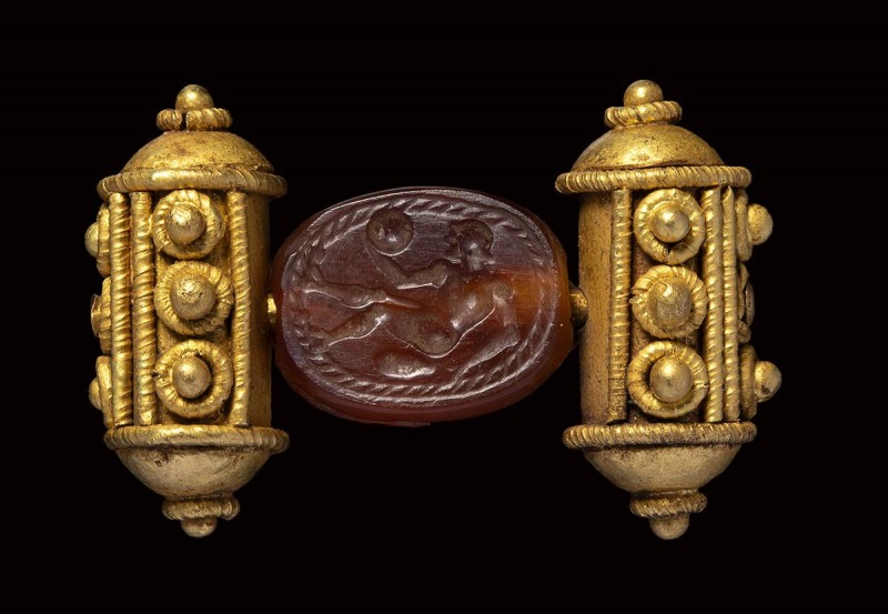 An etruscan carnelian scarab intaglio, mounted on an ancient gold ring. Athlete....