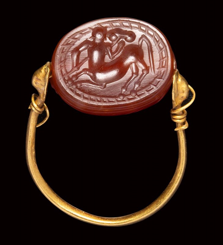 An etruscan carnelian scarab intaglio mounted on an ancient gold ring. Centaur. ...