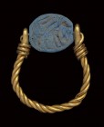 A phoenician blue glass paste scarab intaglio, mounted on an ancient gold ring. Quadrupede