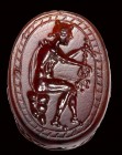 An etruscan carnelian scarab intaglio. Hermes with caduceus.