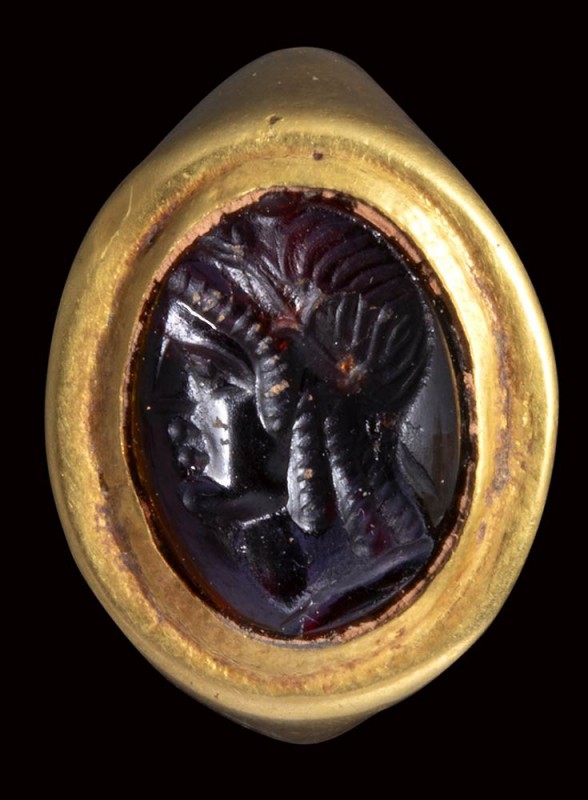 An fine hellenistic garnet intaglio mounted on an ancient gold ring. Bust of Isi...