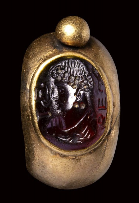 A North-West Indian gold ring with garnet intaglio. Bust of man with inscription...