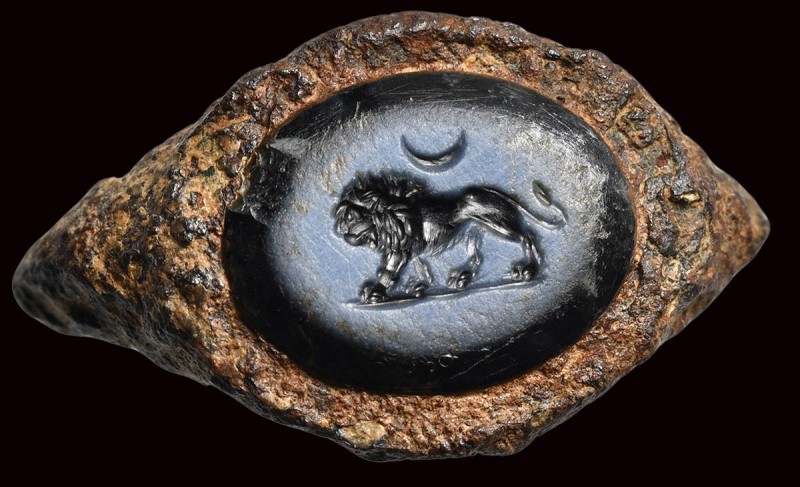 A roman nicolo intaglio set in an ancient iron fragmentary ring. Lion with cresc...