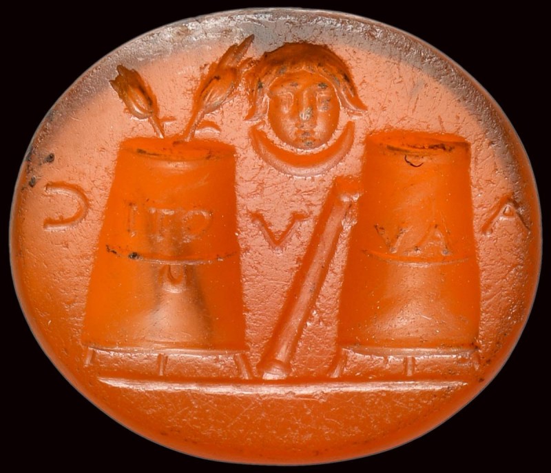 A roman carnelian intaglio. Allegorical emblema with two inscribed modius and ma...