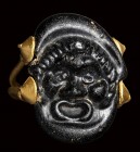 A rare roman black glass cameo  set in an ancient gold ring.  Theatrical mask.