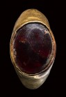 A graeco-roman gold ring set with a garnet cabochon.