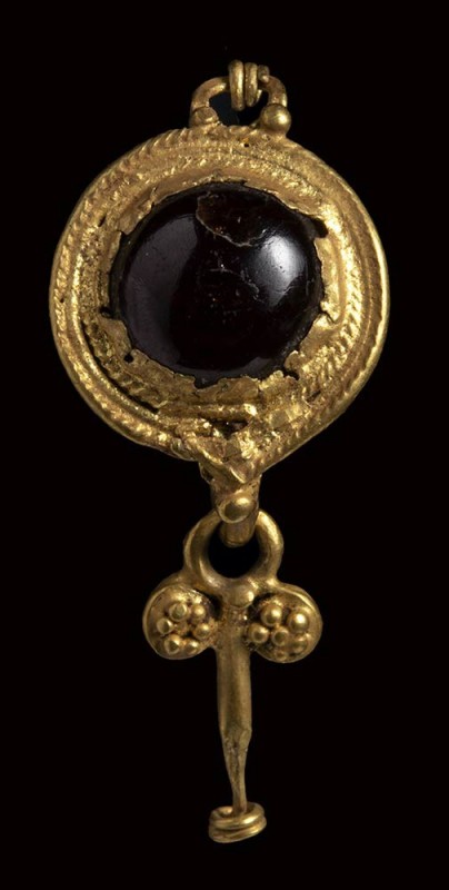 A roman gold and garnet earring with disc and pendant.

2nd century A.D.

H ...