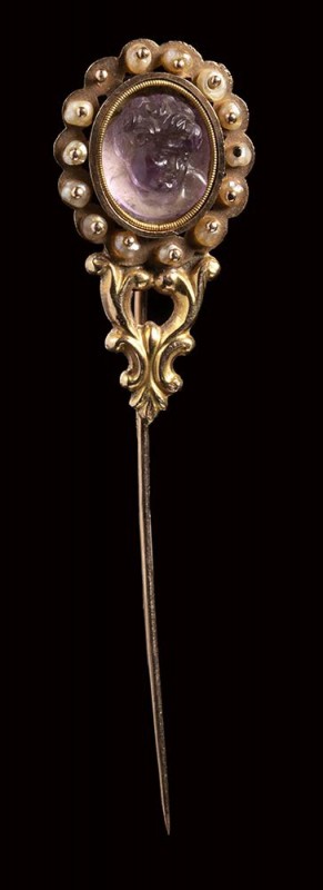A postclassical amethyst cameo set in a gold stick pin with pearls. Bust of Cupi...