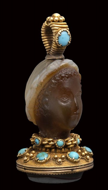 A fine banded agate seal set in a gold mounting with turquoise. Female head. 
...