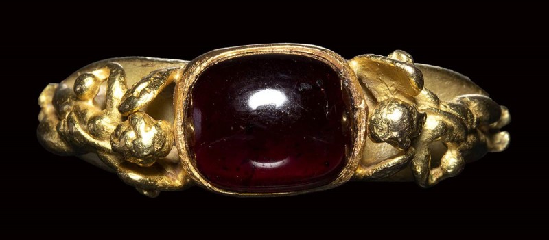 A modern gold ring with a garnet stone. 

20th century

stone : 8 x 10 mmrin...