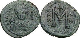 Justinian I (527-565). AE Follis, 546-547, Theupolis (Antioch) mint. Bust facing, helmeted, cuirassed, holding globus cruciger and shield. / Large M (...