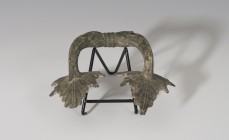 MUNDO ANTIGUO. Greco-Romano. Asa (¿de crátera?) con decoración distal vegetal. Bronce. Longitud 16,3 cm.