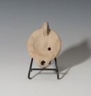ROMA. Imperio Romano. Lucerna (II-III d.C.). Terracota. Busto de Helios de frente. Piquera circular y un agujero de llenado. Longitud 10,7 cm. Pegada