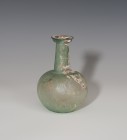 ROMA. Imperio Romano. Botella (Segunda mitad II d.C.). Depósito esférico achatado, cuello largo y boca moldurada. Presenta irisaciones y exfoliaciones...