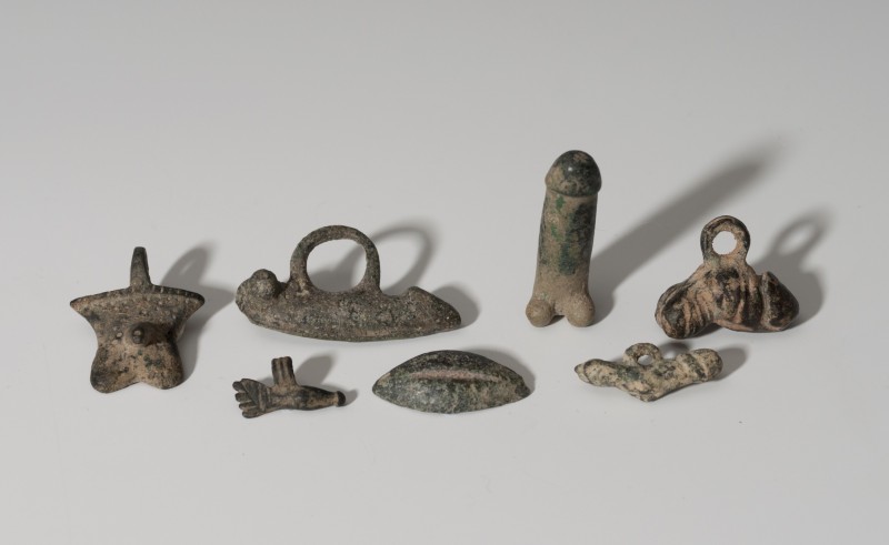 ROMA. Imperio Romano. Lote de siete objetos (I-II d.C.). Bronce. Cinco amuletos ...