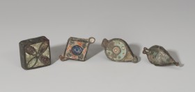 ROMA. Imperio Romano. Lote de 4 guardapelos (III-IV d.C.). Bronce y pasta vítrea. Longitud 2,9-3,1 cm.