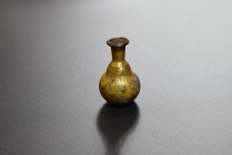 Yellow clear glass flask with globular body and long neck. Eastern Mediterranean, 1st-2nd cent. AD (55.3x36.4 mm). Almost intact