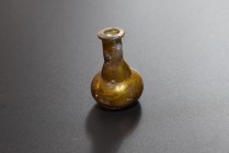 Glass flask. Eastern Mediterranean, 1st-2nd cent. AD (50.3 x 31.9 mm). Delicate unguentarium with drop-shaped base. Greenish clear glass. Beautiful ir...