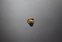 Golden ring with gemstone of red cornelian depicting an animal with horns coming out of a calyx. AV (16.6 mm, 2.07 g). 2nd-3rd cent. AD. Intact