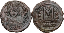 Justinian I (527-565). AE 40 Nummi, Nicomedia mint, year 32 (558/9). Helmeted and cuirassed facing bust, holding globus cruciger and shield; cross to ...