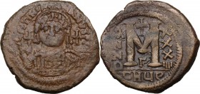 Justinian I (527-565). AE Follis. Theoupolis (Antioch) mint. Dated RY 34. Bust facing, helmeted, cuirassed, holding globus cruciger and shield. / Larg...