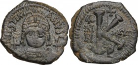 Justinian I (527-565). AE 20 Nummi, Antioch mint, year 32 (558/9). Helmeted and cuirassed bust facing, holding globus cruciger and shield; cross to ri...