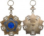 CHINA
The Order of the Brilliant Jade
A 5th Class badge in gilt silver, 66,0 x 62,5 mm., with pale blue enameled centre, set with a carved, blue jad...