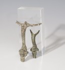 ROMA. Lote de dos asas de jarra (I a.C. - IV d.C.). Bronce. Una con decoración distal cefaliforme y otra zoomorfa. Altura 5,8 y 7,9 cm.