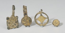 VISIGODO. Lote de cuatro colgantes y/o apliques (VI-VI d.C.). Bronce dorado. Con decoración esquemática, vegetal y crismón. Altura 1,0-3,2 cm.
