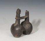 PREHISPÁNICO. Cultura Chimú. Botella de doble cuerpo (1100-1470 d.C.). Cerámica de barniz negro. Con silbato antropomorfo. Altura 16,6 cm.