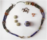 ANTIKE.
PERLEN.
KETTEN. Kette aus Lapis-Lazuli-Perlen 3. Jahrtausend vor Chr., 3-fädrig bis 5-fädrig aufgezogen mit runden Glasperlen, silbrigen run...