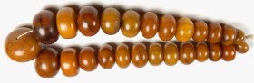 AFRIKA. 
KETTEN. Hochzeitskette Amber-Copal Handelsperlen, 27 kugelige seitlich abgeflachte braungelbe Perlen F 23-53mm, Kette L. ca. 72cm. .
