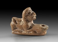 Terracotta lamp of brown clay with redbrown slip depicting a crouching lion. Roman, 1st - 2nd century AD, Fragment of the back of the lion missing, 7,...