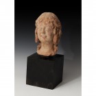 GRECIA. Período helenistico. Cabeza femenina (III-II a.C.). Terracota. Dimensiones 25,5 x 10,0 cm. Incluye peana