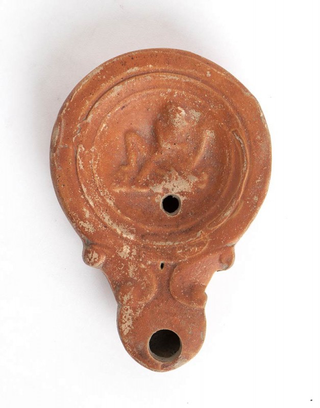 LUCERNA CON SUONATORE DI LIRA
 I - II secolo d.C.; lungh. cm 10,5; Sul disco, u...