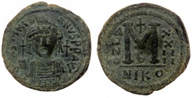 JUSTINIAN I (527-565). AE35 Follis. Nicomedia. Dated RY 24 (550/1).
Obv: D N IVSTINIANVS P P AVG, Helmeted and cuirassed bust facing, holding globus c...