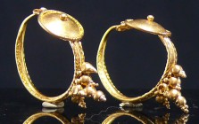 Romain - Boucles d'oreille en or - 0 / 200 ap. J.-C.
Jolie paire de boucles d'oreille en or, ornées d'un bouclier et d'une sorte de grappe pendante. ...