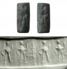 A ?Gnostic? grey stone cylinder seal, Roman, 3rd - 4th Century A.D. depicting a standing figure (Hermes?) and Sol, with three pseudo-letters in field....