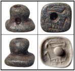 A green-black chlorite stamp seal, Southern Anatolia, ca. 2000 - 1500 B.C. with square shape and knob handle, the base featuring a hawk above an antel...